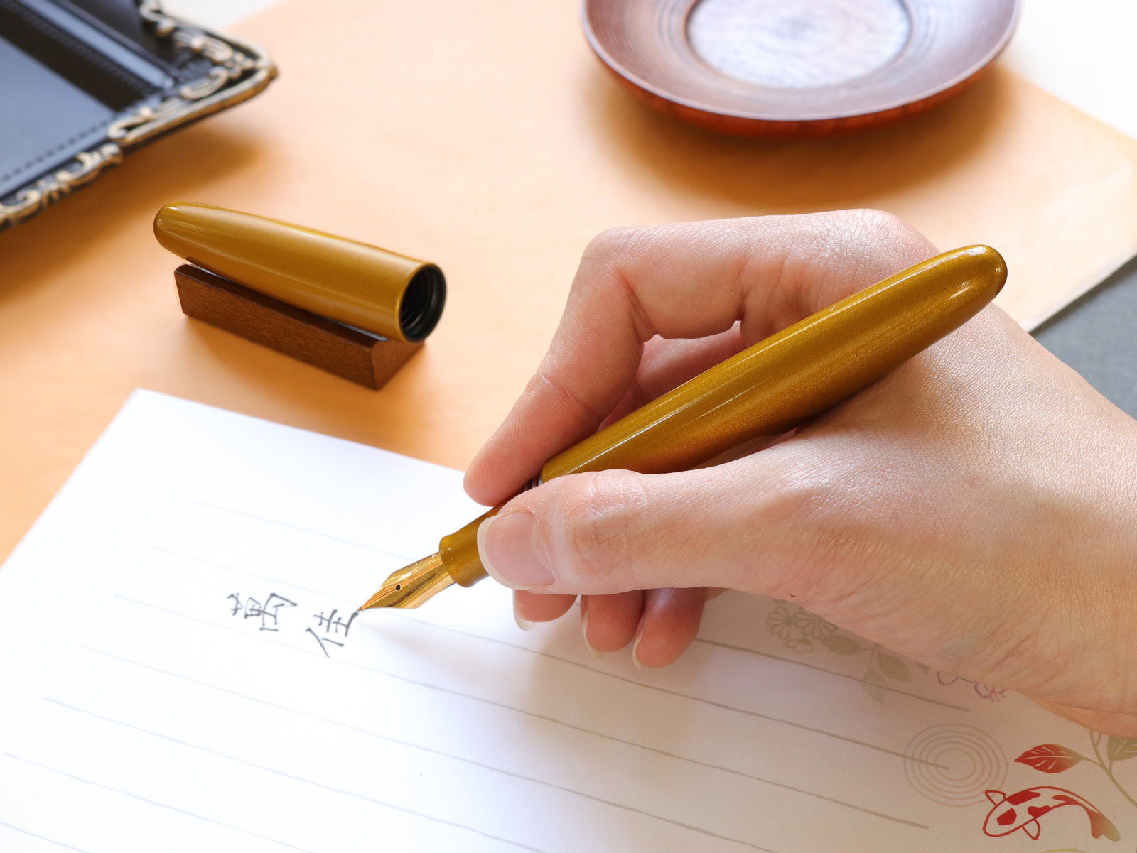 Hand writing on paper with a wooden fountain pen.