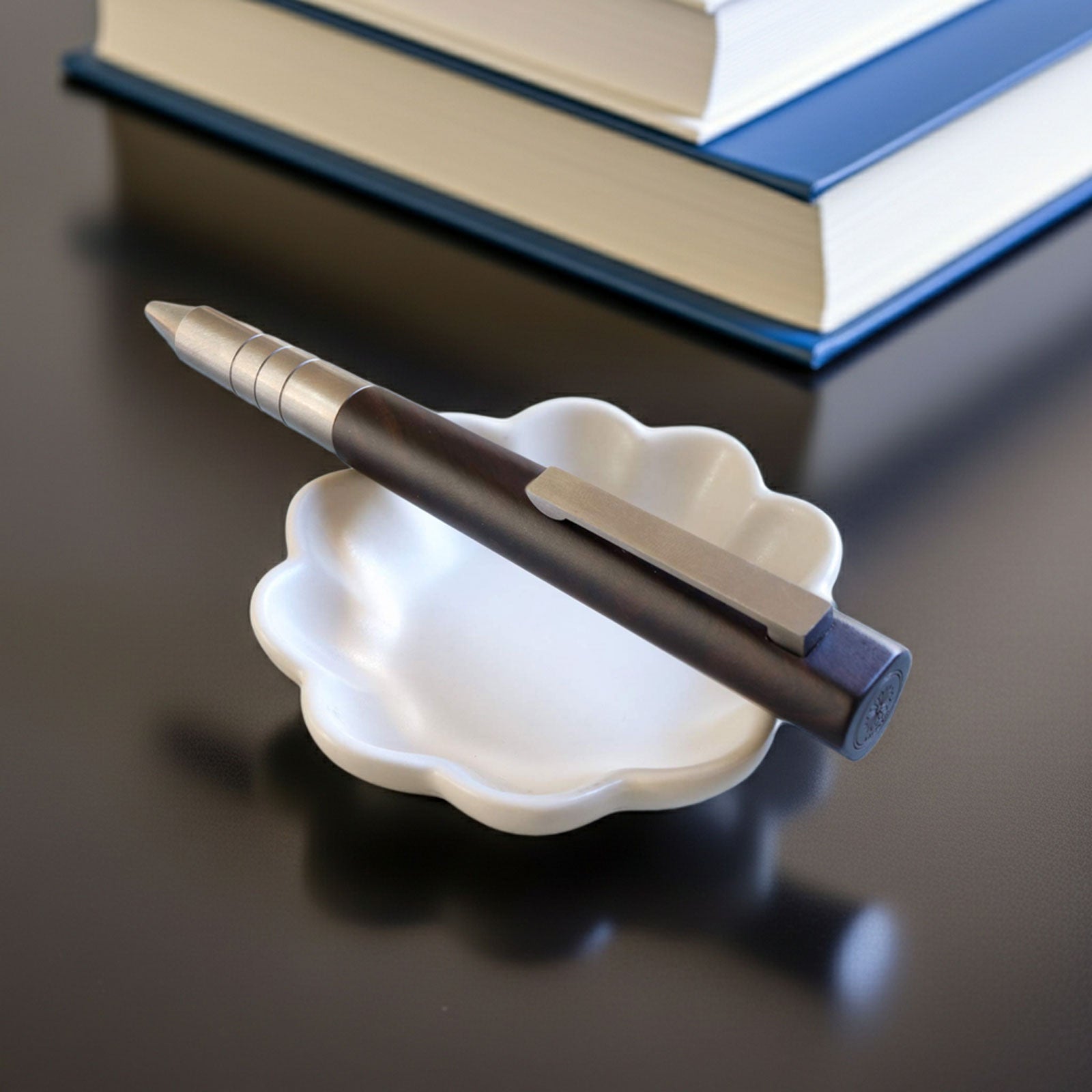Wancher Meiji Ballpoint Pen on a white stand with books in the background