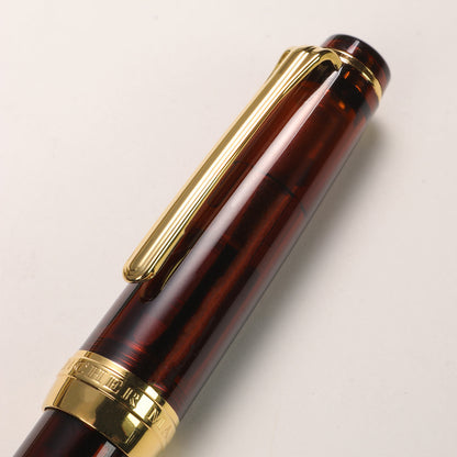 Brown pen with gold accents on a light gray background