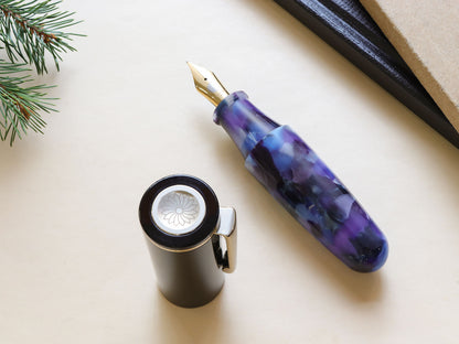 Uncapped Pochaco midnight violet with purple and black hue on top of bright background and books