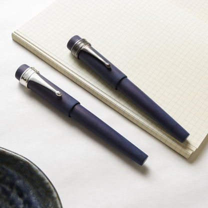 Sekai Ai with silver and matte pen clip on top of paper