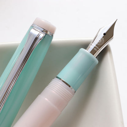 Close-up of a Wataame fountain pen showing the 14K nib in Rhodium-plated , the body is in light blue with soft pink.